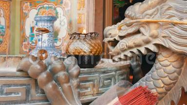 中国风格的原始烛台。 一尊龙铜像和一支燃烧的蜡烛